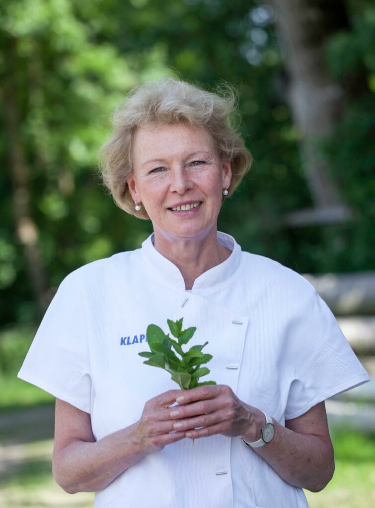 Margret Hecker mit Pflanzenblätter in der Hand